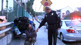 San Diego Police Sgt. Rick Schnell, the leader of the Homeless Outreach Team, greets a homeless man after telling him he needs to move his belongings off of a bridge.