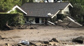 This photo provided by the Santa Barbara County Fire Department shows a home that has been buried in flood debris in Montecito, Calif., Tuesday, Jan. 9, 2018. 