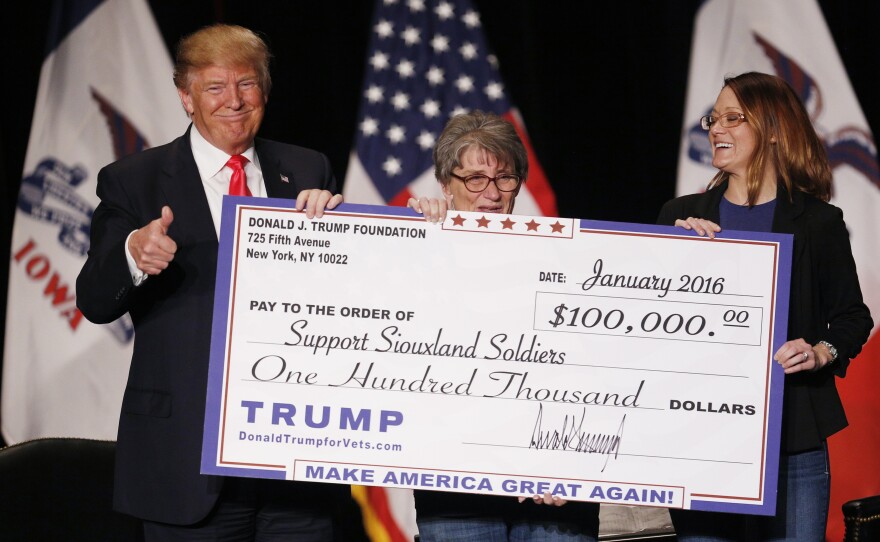 Donald Trump awards a $100,000 check to a veterans charity in Sioux City, Iowa, during a 2016 event. His use of the Trump Foundation during the campaign raised legal questions about its activities.