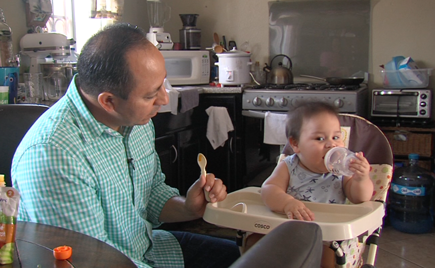 Eduardo Bohorquez feeds his son, July 27, 2016. 