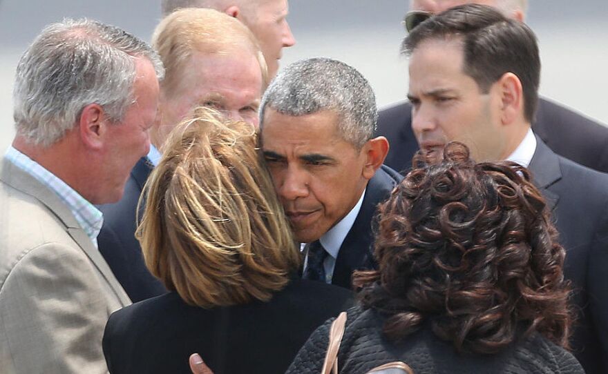 President Obama hugs Orange County Mayor Teresa Jacobs as Orlando Mayor Buddy Dyer (left) watches, at Orlando International Airport on Thursday.