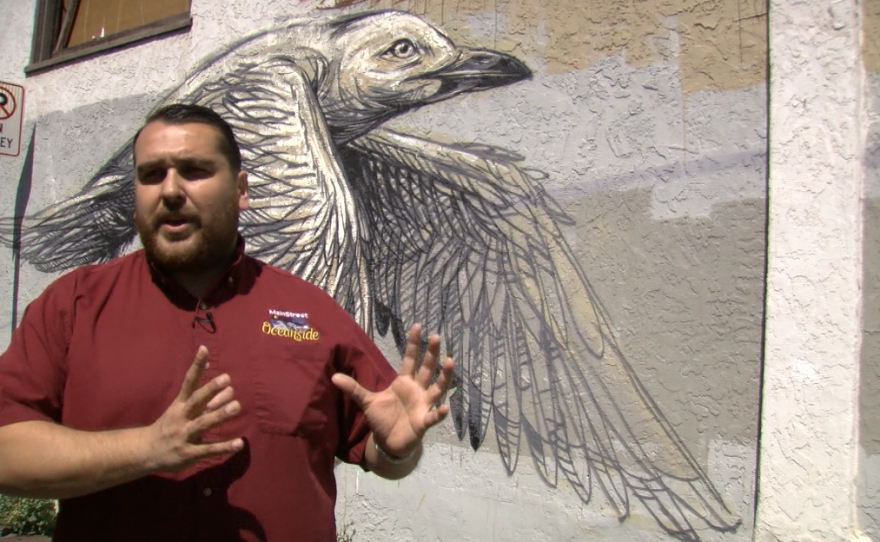 Gumaro Escarcega of MainStreet Oceanside stands beside an unfinished mural called "A Flock of Birds," March 28, 2017.