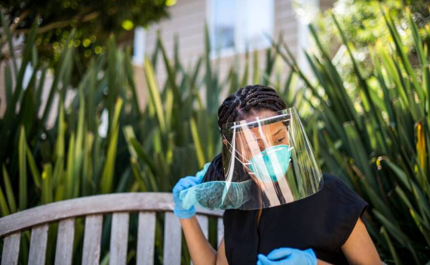 Dr. Tiffany Chioma Anaebere removes the medical gear that she uses as an emergency room doctor in this undated photo.