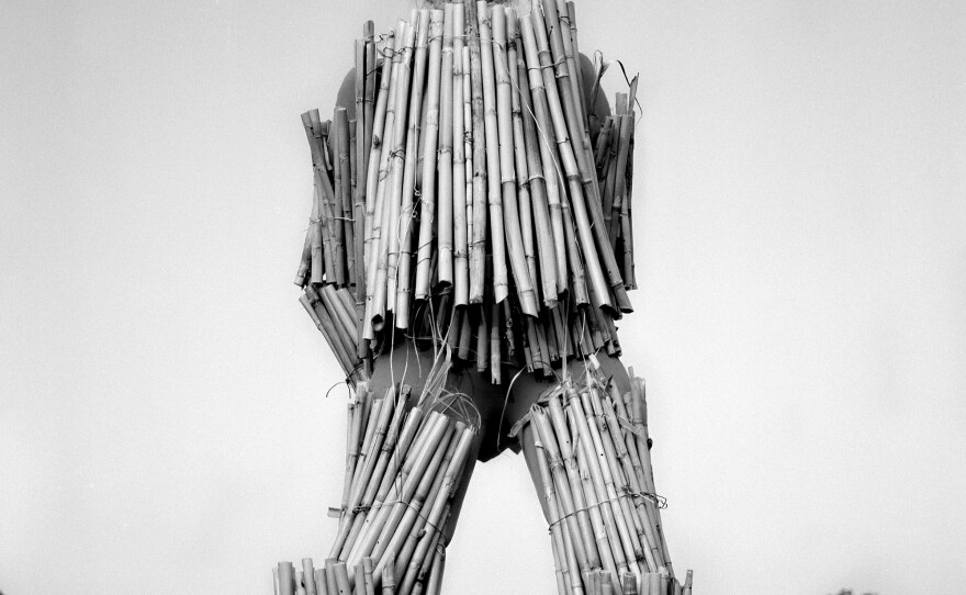 <em>Visible</em>, 2020. I took measurements of Marcia's body and cut dried bamboo from her garden to fit her as armor, or rather as a shelling. Here, she's standing on a giant boulder even though she's afraid of heights. The air is still. All we can hear are distant cars zooming by on nearby highways.