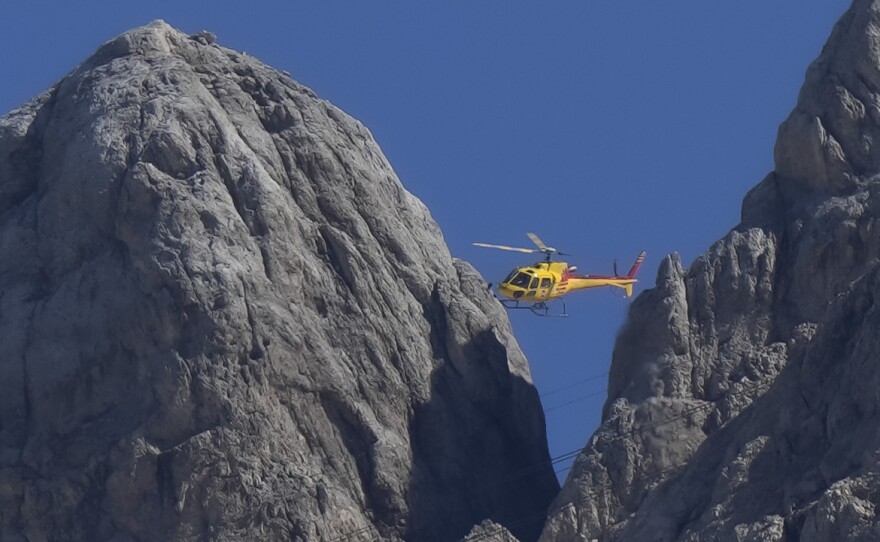 A rescue helicopter hovers over the Punta Rocca glacier near Canazei, in the Italian Alps in northern Italy, on Monday.