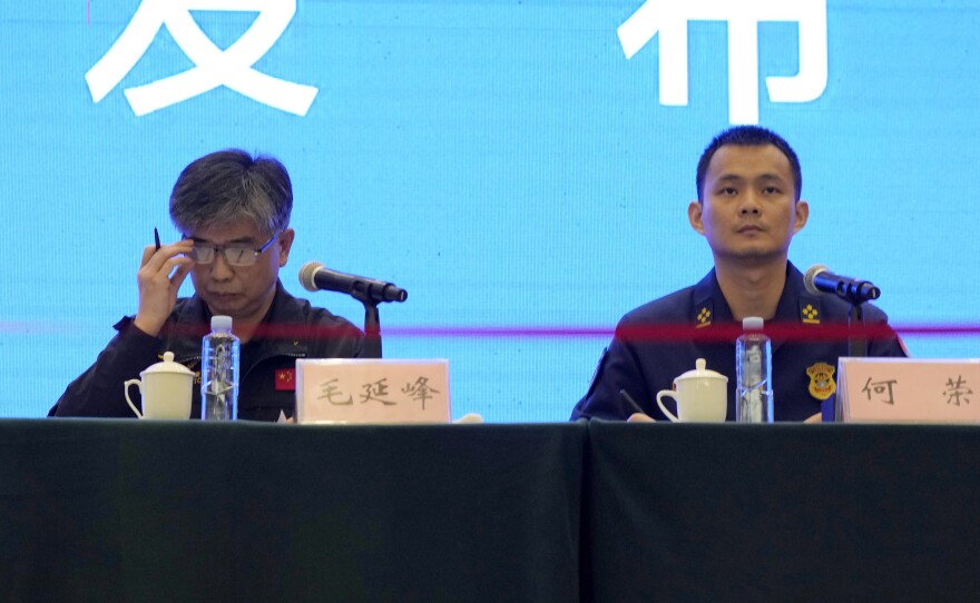 Mao Yanfeng, the director of the accident investigation division of the Civil Aviation Authority of China (left), and He Rong from the Guangxi Fire and Rescue Force attend a press conference in Wuzhou city on Wednesday in southwestern China's Guangxi province. China says one of two so-called black boxes from Monday's plane crash was found in severely damaged condition.