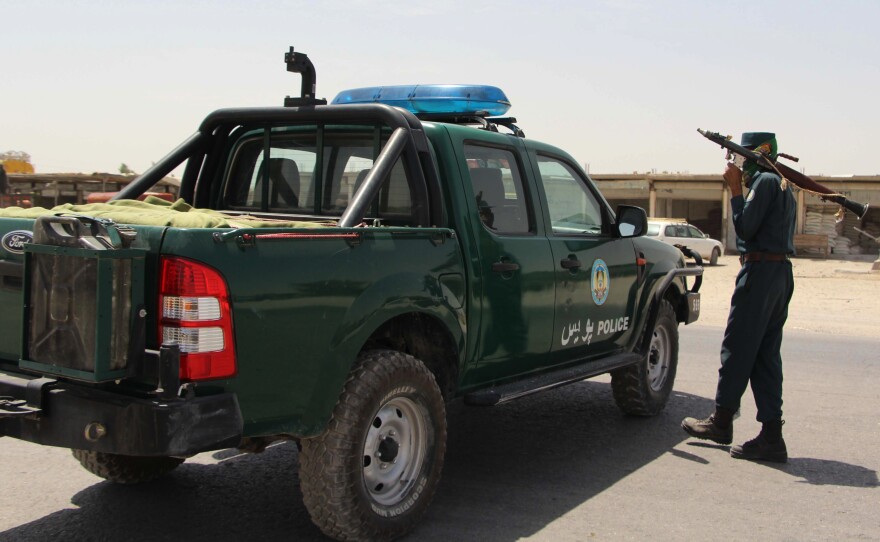 An Afghan policeman holds a rocket-propelled grenade during an ongoing battle with Taliban militants in the Gereshk district of Helmand province Saturday. A U.S. airstrike killed 16 policemen in the area on Friday, local officials said.