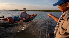 Local fisheries on the coast of Cambodia struggled with decimated fish populations for years. Today, they are teeming with seafood, thanks to local ecological restoration efforts. Here (at right), Koh Kresna village chief Khiev Sat talks with a fisherman about the day's catch.