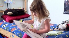 Four-year-old Gabriella Anderson spends her free time reading a hardback book in her brothers' bedroom.  