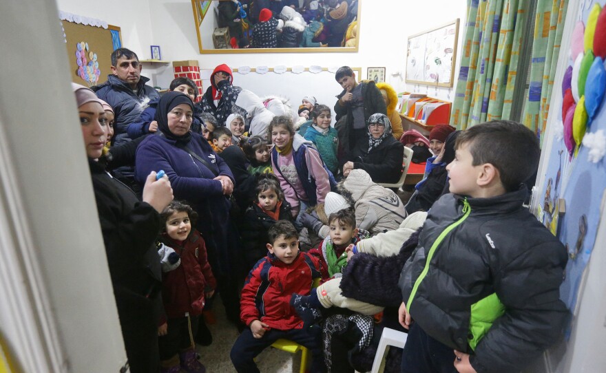 People gather at a convent to spend the night as they fear more tremors following a deadly earthquake on Monday, in Aleppo, Syria.