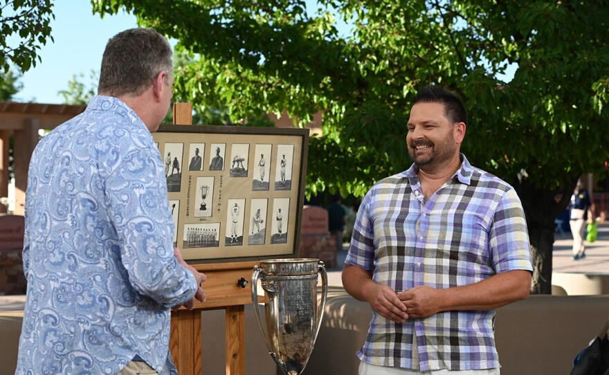 Grant Zahajko  (left) appraises a 1916 - 1917 New Mexico Mining League trophy & photos, in Santa Fe, N.M.