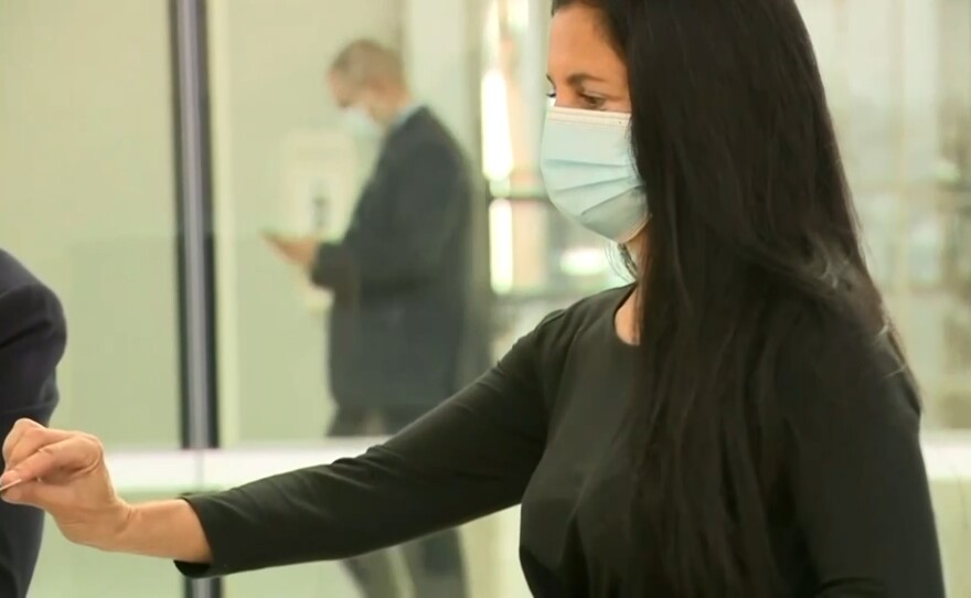 San Diego businesswoman Gina Champion-Cain showing her ID as she is walking into court, March 31, 2021.
