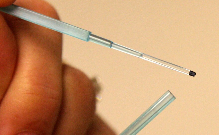 Britain could become the first country to legalize the production of a human embryo from three donors. Here, the freezing platform for an embryo, top, also known as a straw, is seen at an in vitro fertilization lab.