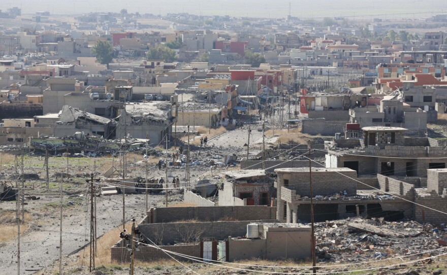 Kurdish peshmerga fighters, seen in the center of this image, enter Sinjar on Friday, after taking the town from the self-proclaimed Islamic State group in a joint operation with coalition forces.