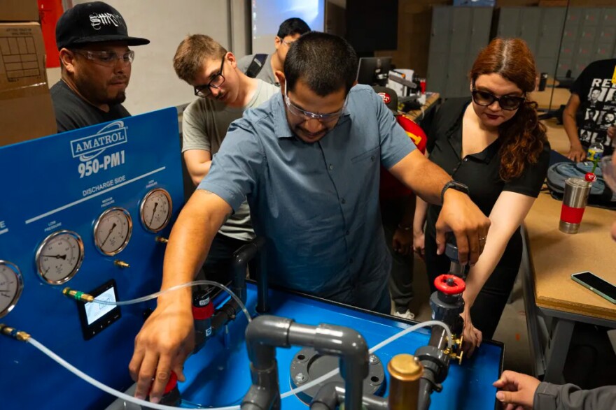 Rafael Serrano (center) works with Corban Dillon (left), Dylan Charles and Jacqueline Boratynski (right) to calibrate a model pump on Oct. 5, 2023. Students learn the math and how to apply it to real world situations.