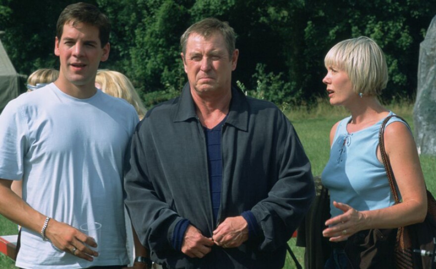 Sergeant Dan Scott (John Hopkins), DCI Tom Barnaby (John Nettles) and wife Joyce Barnaby (Jane Wymark) in a scene from MIDSOMER MURDERS: Season 7, episode 3 “Fisher King.”
