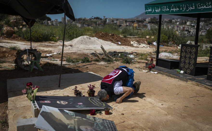 Mohammed Suleiman, Nabatieh's chief paramedic, prays at the grave of his son, Joud Suleiman, in Nabatieh on May 14.  Joud was killed in an Israeli strike in March.