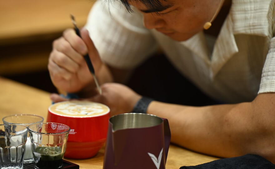 A competitor for the World Latte Art Championship adjusts his foam art at the San Diego Convention Center on April 10, 2026.