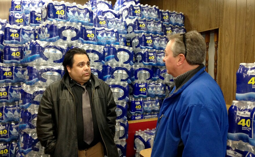 Carlos Amos, manager of Angelo's Coney Island in Flint, Mich., talks to Anthony Pavone, supervisor of the Genesee County Health Department. Amos says the restaurant's owner got a good deal on bottled water that customers can choose to buy.