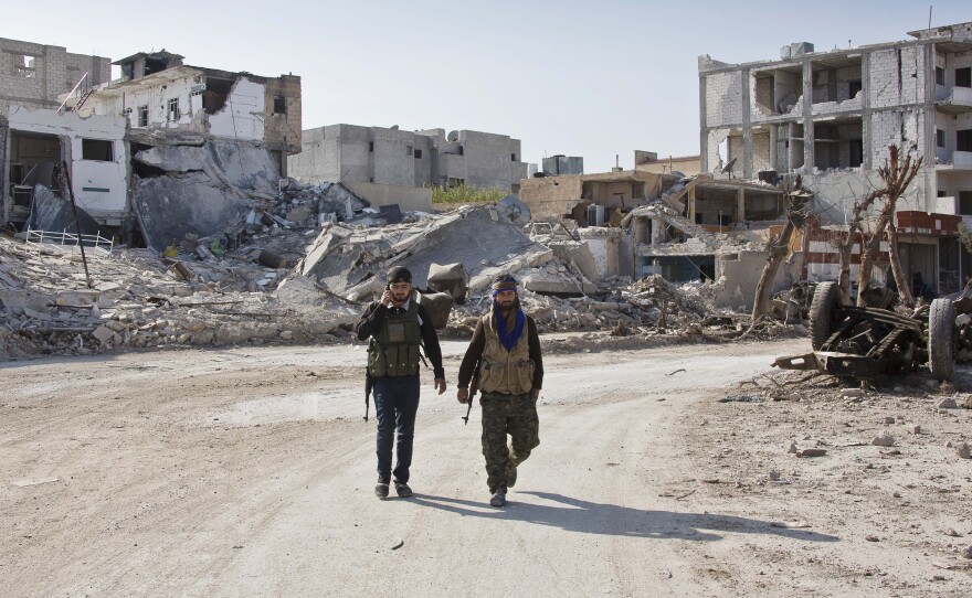 Kurdish rebels in northern Syria walk near the devastated town of Kobani last November. The U.S. bombing campaign helped the Kurds push back the Islamic State from the area. But overall, the U.S. operation against ISIS in Iraq and Syria has shown only limited gains in the past year.