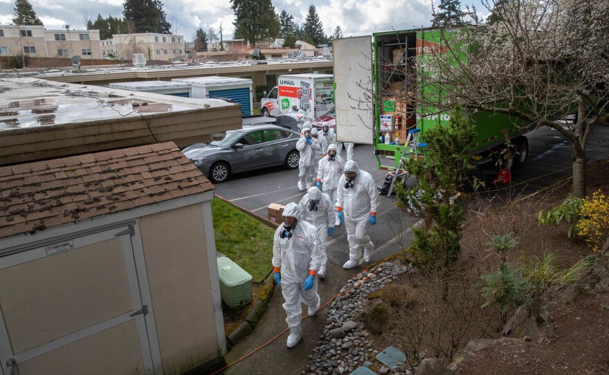 A cleaning crew wearing protective clothing enters the Life Care Center in Kirkland, Wash., in March 2020. The nursing home had some of the earliest deaths in the U.S. due to COVID.