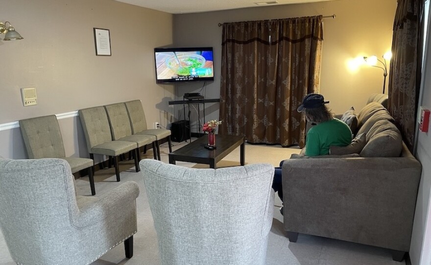 A resident watches a cooking show in the living room at Hope Has a Home medical respite in Washington, D.C.