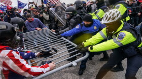 FILE - Trump supporters try to break through a police barrier, Jan. 6, 2021, at the Capitol in Washington.