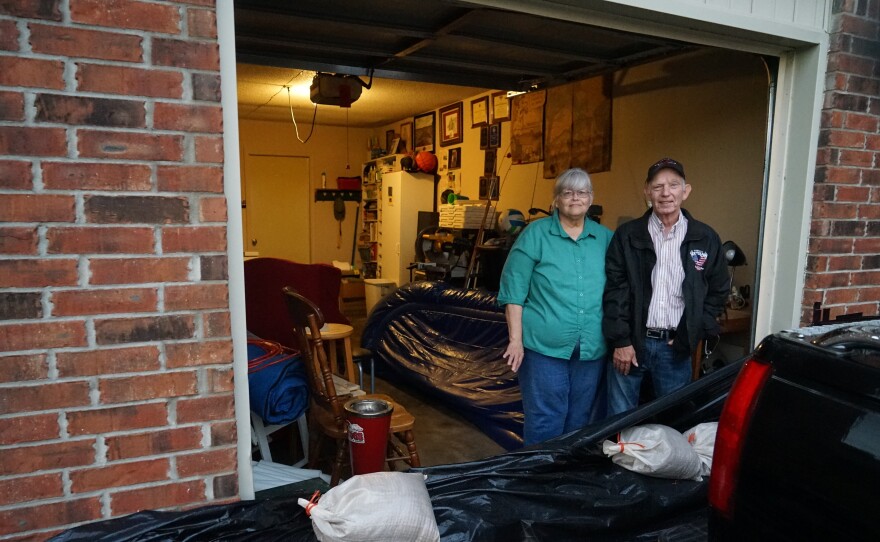 John and Louise Hutchins stand in their garage in Fort Smith, Ark., behind a homemade sandbag barrier. They chose not to evacuate, in part because they did not think their neighborhood would flood.
