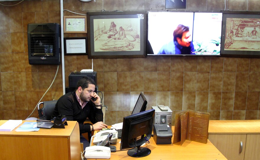 David Shumer handles takeout orders at a kosher restaurant in Tehran that his family has run for 35 years. He has a comfortable, middle-class life and says he is happy in Iran.