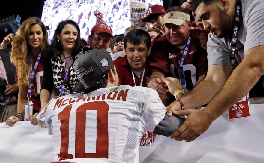 Katherine Webb (left), the girlfriend of Alabama quarterback A.J. McCarron, and McCarron's mother, Dee Dee Bonner (second from left), watch McCarron celebrate after the BCS National Championship college football game on Jan. 7. Webb was caught on camera and announcer Brent Musburger enthusiastically remarked that quarterbacks "get all the good-looking women." ESPN later apologized.