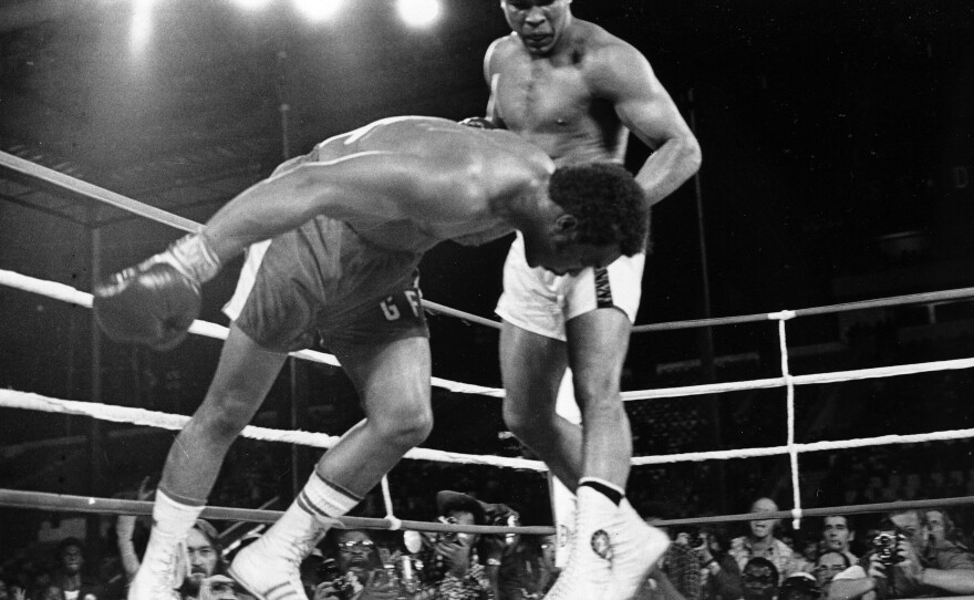 Ali watches as defending world champion George Foreman goes down to the canvas in the eighth round of their WBA/WBC championship boxing match in Kinshasa, Zaire, on Oct. 30, 1974. Foreman was counted out by the referee and Ali regained the world heavyweight crown by knockout.