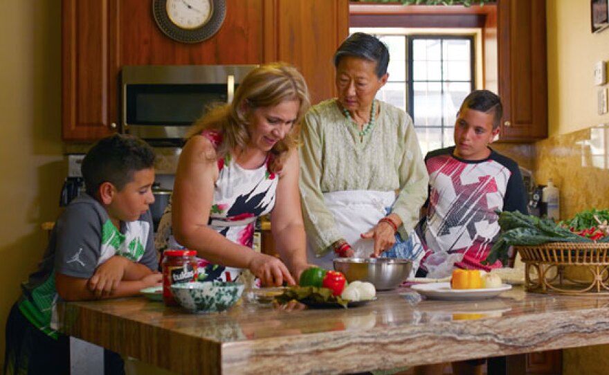 Host Su-Mei Yu (third from left) cooks a delicious meal with a refugee family who now calls El Cajon, Calif. home.