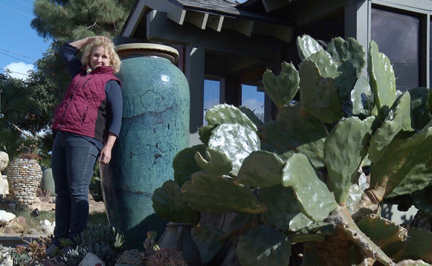 Host Nan Sterman stands next to a very tall Laird Plumleigh pot. Ceramicist Laird Plumleigh has a garden filled with cacti, succulents, and unusual plants that reflect the colors and textures of his home.