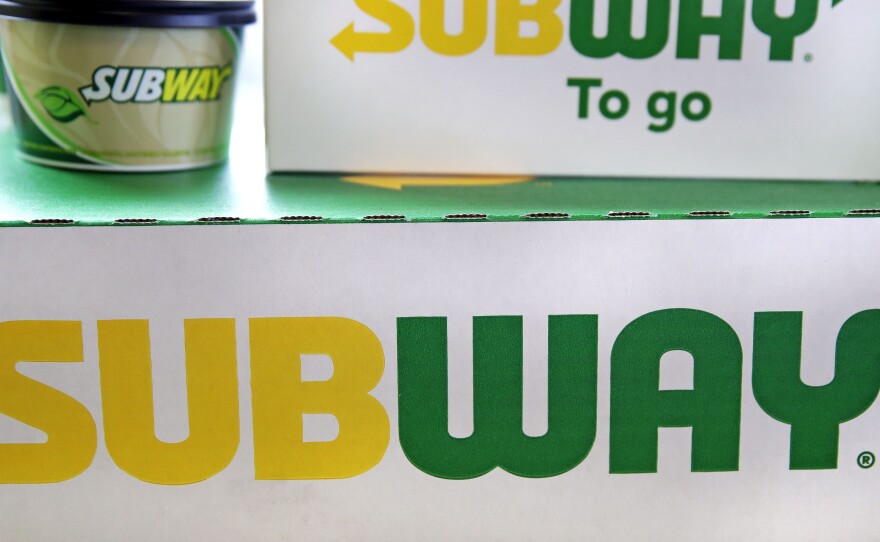The Subway logo is seen on takeout boxes at a restaurant in Londonderry, N.H. The sandwich chain says it will be sold to the private equity firm Roark Capital. Terms of the deal weren't disclosed.