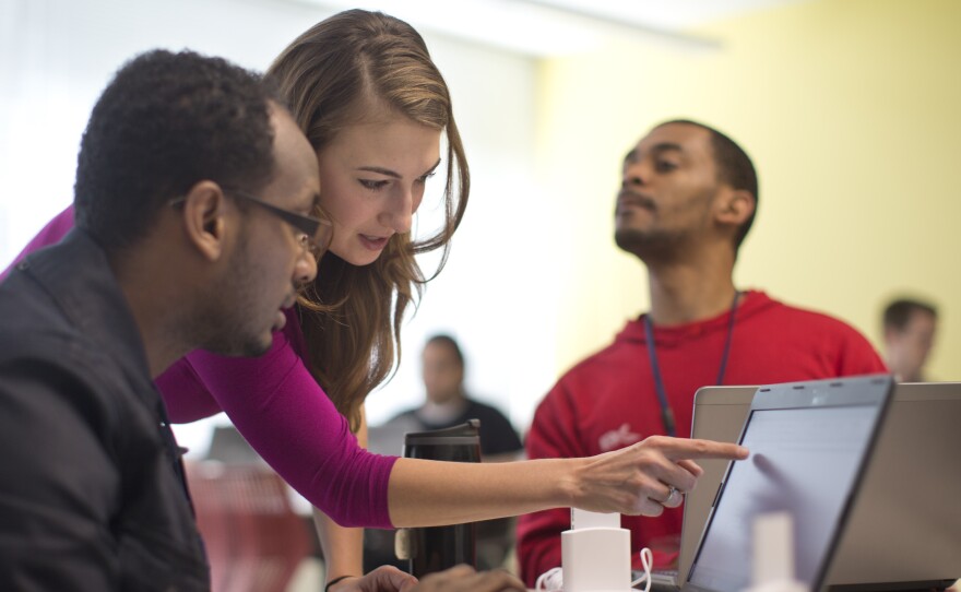 Kaylin Wainwright (center) works with student Natnael Gebremariam (left) during a GED preparation class in Washington, D.C. Seated at right is student Sibusiso Kunene.
