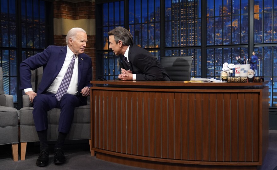 President Biden talks with Seth Meyers during a taping of NBC's <em>Late Night with Seth Meyers</em> on Feb. 26 in New York.