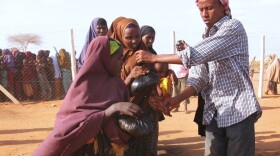Women and children at the Dadaab refugee complex in Kenya line up Aug. 24 to  receive iftar — a meal of rice, meat and vegetables to break  the Ramadan fast. Somalis are fleeing across the border to Kenya to escape  extreme poverty associated with the country's severe drought, famine and an  Islamist insurgency.
