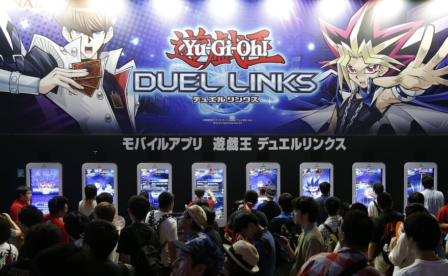 Visitors play Yu-Gi-Oh! Duel Links at the Tokyo Game Show in 2016 in Chiba, Japan.