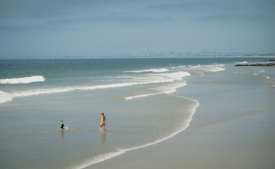 Beachgoers play in the ocean next to the Imperial Beach Pier in Imperial Beach on September 3, 2024.