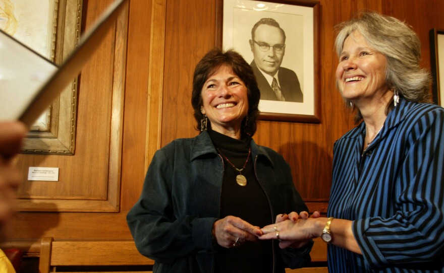 At Cambridge City Hall in Boston, Marcia Kadish (left) and Tanya McCloskey exchange rings as they are married before Clerk D. Margaret Drury on May 17, 2004. They were the first couple to be married in Cambridge that morning.