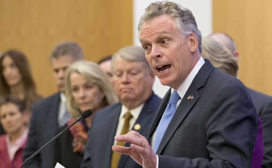 Virginia Gov. Terry McAuliffe is joined by members of the House and Senate as he announces a compromise on a set of gun bills at the Capitol in Richmond, Va., on Friday.