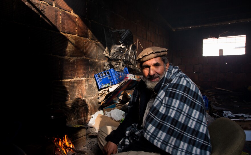 Mangal Saifullah, 57, from Afghanistan prepares his lunch, boiling some water on an improvised fire near his shelter in the former Krajina Metal factory. He has been in Bosnia for a year.