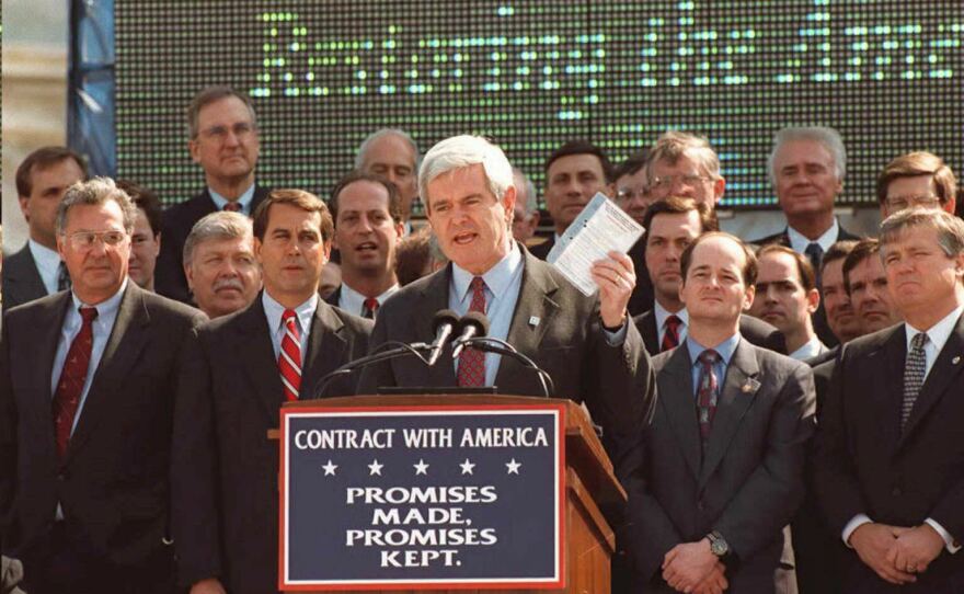 House Speaker Newt Gingrich (center), shown here surrounded by House Republicans, holds up a copy of the "Contract With America" during a speech on April 7, 1995 on the steps of the U.S. Capitol in Washington.