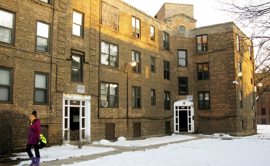 A resident of Lathrop Homes leaves one of the few occupied buildings in the development. The city wants to redevelop the public housing as mixed use, and offered vouchers to encourage residents to relocate.