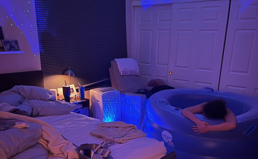 Emily lies in a birthing tub in her bedroom during her home birth, Oct. 2022.