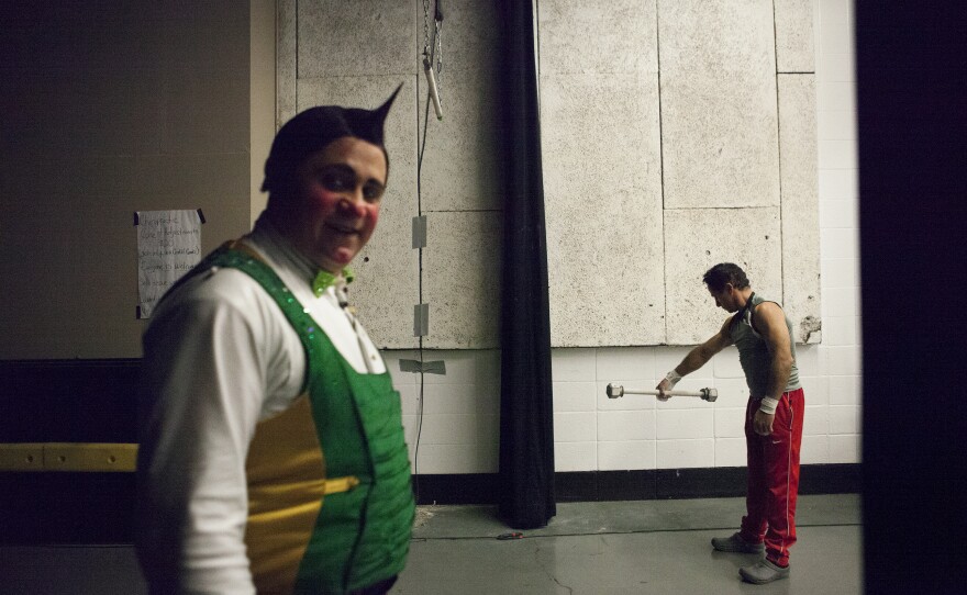 Clowns and trapeze artists loosen up backstage before the show.