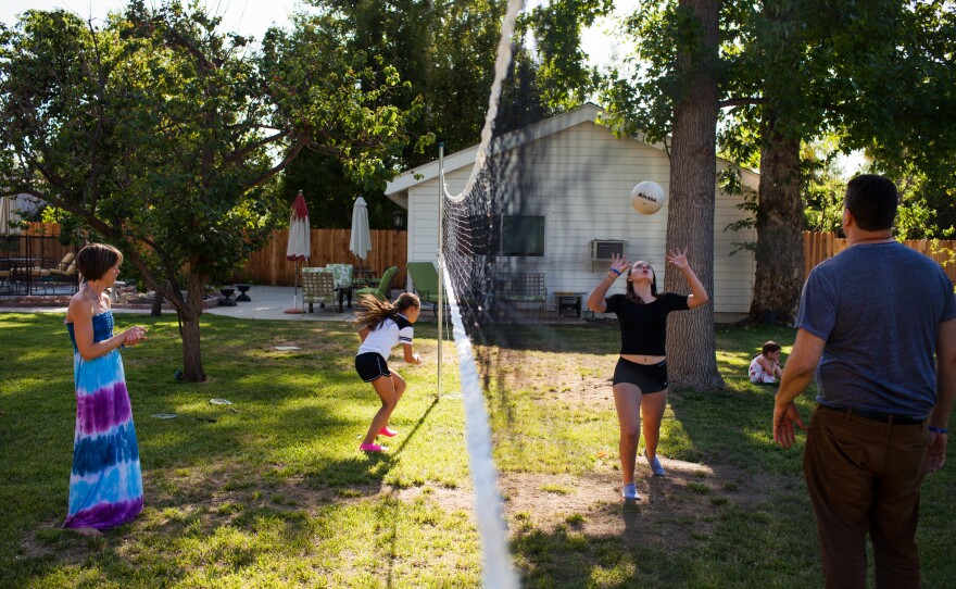 The Glasser family plays volleyball in their backyard.