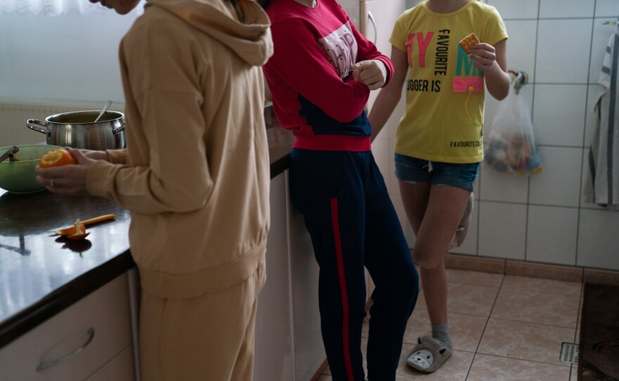 Three Ukrainian girls hang out in the kitchen of their new foster home in Poland.