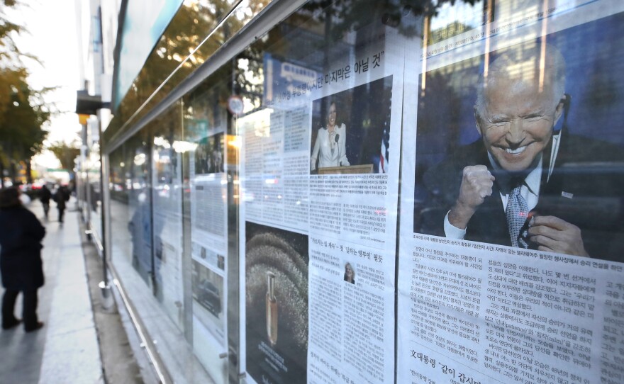 A newspaper's front page featuring President-elect Joe Biden and Vice President-elect Kamala Harris is displayed on a sidewalk in Seoul, South Korea, on Monday.