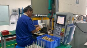 A worker at Thinova Magnet Co. Ltd. puts rare earth magnets into a press at a factory in Zhejiang province.